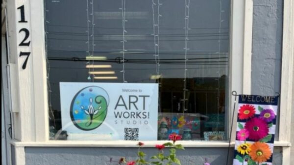 a window with a sign that read art works studio and the nubers 127